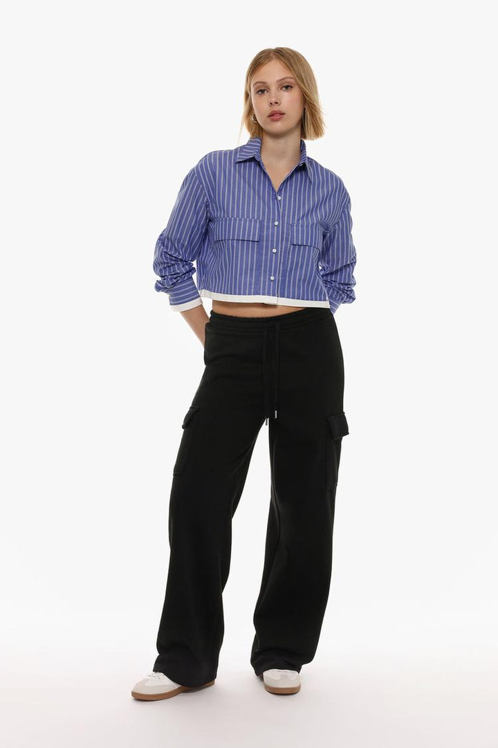 Image of black wide-leg cargo trousers, highlighting their loose, relaxed fit and functional design with multiple pockets.