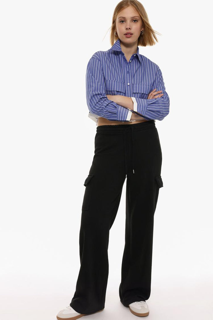 Full-body image of someone wearing black wide-leg cargo trousers, showing the trousers as part of an entire outfit.