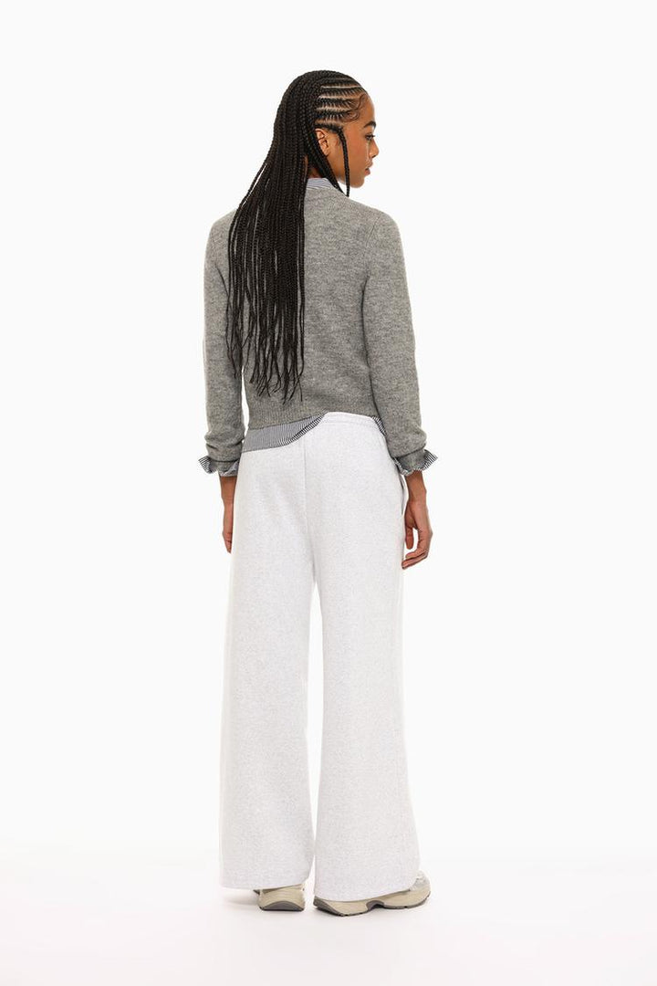 Front view of grey wide-leg plush trousers highlighting the waist and leg fit.