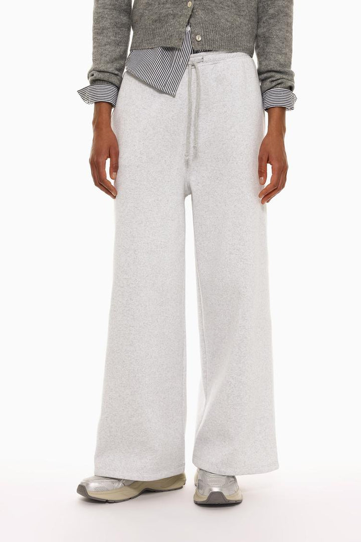 Side view of grey wide-leg plush trousers showing the overall silhouette.