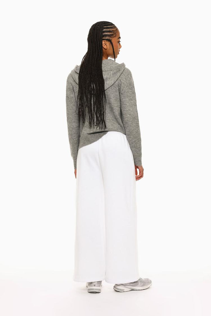 Front view of white wide-leg plush trousers highlighting the waist and legs.