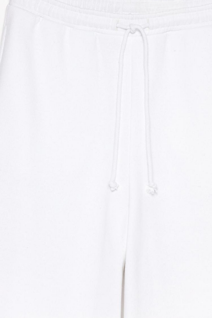 Product view of white wide-leg plush trousers showing fabric and styling.
