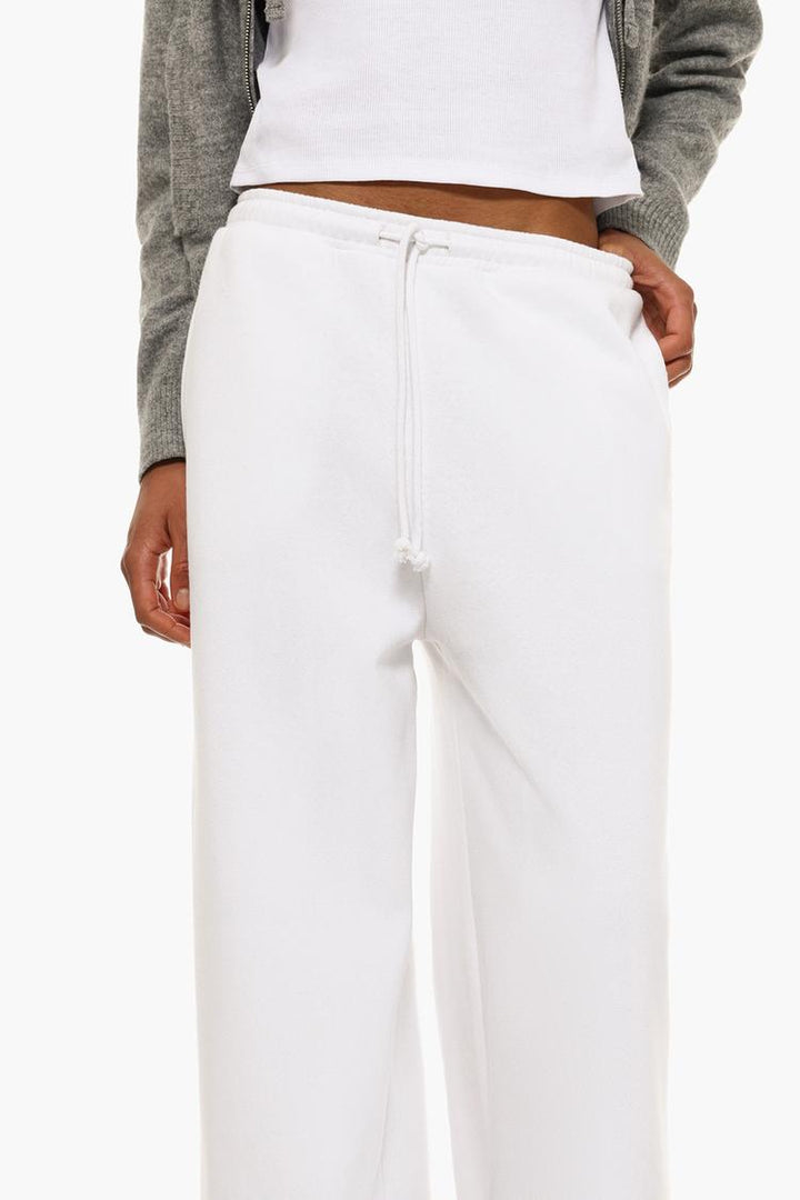 Side view of white wide-leg plush trousers to highlight the overall fit.