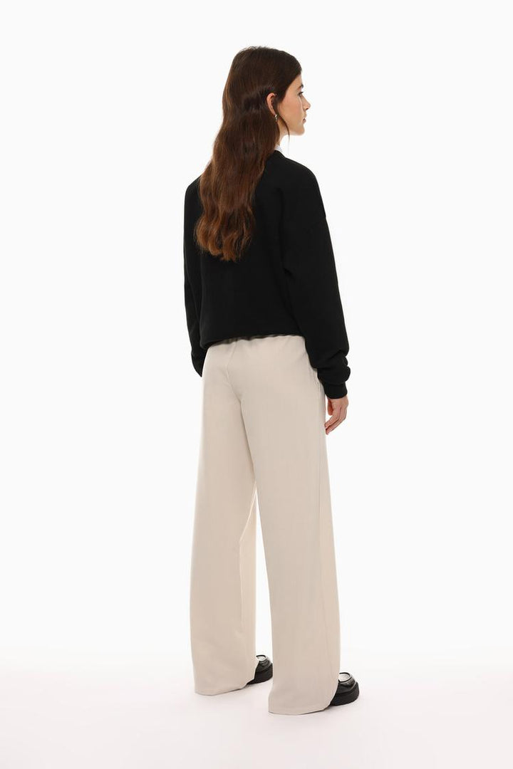 Back view of beige wide-leg smart trousers, showcasing the well-crafted details and fit