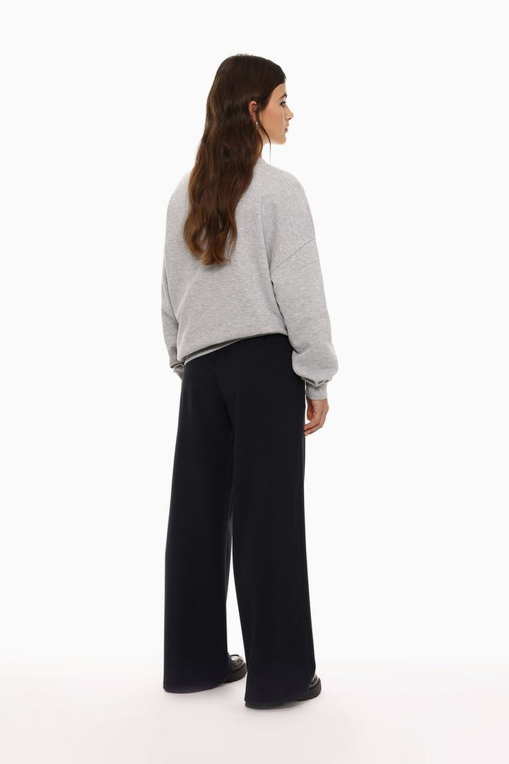 Back view of black wide-leg smart trousers, featuring a smooth and tailored silhouette