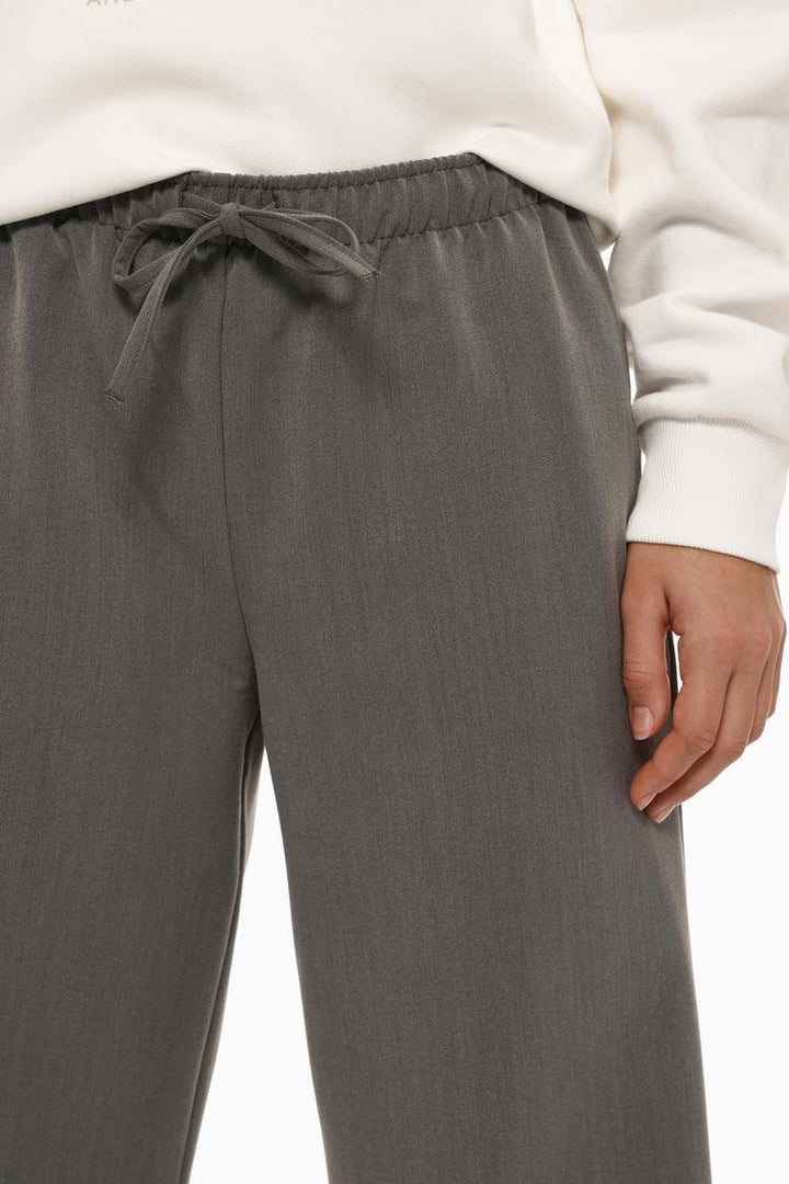 Body shot of grey wide-leg smart trousers, showcasing their flattering and tailored fit